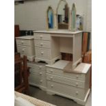 A white laminate bedroom suite comprising 2 x 3 height chests; 2 height bedside cabinet and dressing