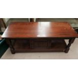 A Jacobean style oak 2 tier coffee table with rectangular top and linen fold cupboards