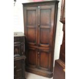 A 19th century oak full height corner cupboard enclosed by 2 pairs of panelled doors
