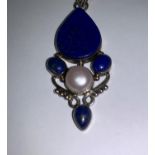 An Art Nouveau style pendant on chain, stamped 925, set with lapis lazuli coloured stones and