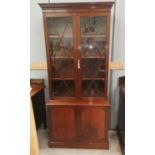 A reproduction Georgian style mahogany bookcase with twin astragal glazed doors over cupboard
