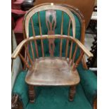 A 19th century child's elm Windsor armchair with pierced splat and solid seat, on turned legs