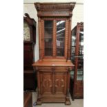 A Victorian Gothic revival medium oak bookcase, full height, the upper section with carved moulded