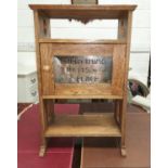 An Arts & Crafts oak side table, the central cupboard enclosed by a door with anodised plaque "