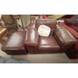 A large club style armchair and pouffe in brown leather