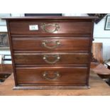 A walnut jewellery / correspondence cabinet with 4 drawers and brass drop handles