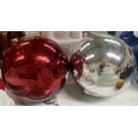 A large silvered glass mirror ball; another in red glass