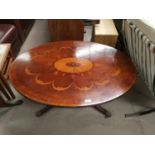 A reproduction mahogany pedestal coffee table with oval top