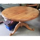 A pine single pedestal dining table with circular top