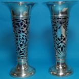 A pair of hallmarked silver posy vases with pierced decoration flared rim, blue glass sleeves (1 af)