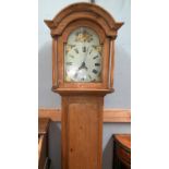 A 19th century pine 30 hour longcase clock with arch top hood and turned pillars, full length door