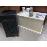 A small black bedside cabinet with pierced leaf panels; a cream painted blanket box