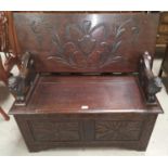 An early 20th century carved oak monks bench