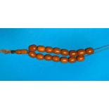 A necklace of butterscotch coloured beads on metal chain, 15 oval shaped beads, 50 gm gross,