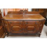 A 1930's oak sideboard with 2 drawers and double cupboard enclosed by raised octagonal panel doors