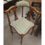 A pair of Edwardian corner armchairs, upholstered seats in green, on turned legs