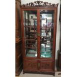 A mid 20th century Chinese hardwood display cabinet with vine carved decoration, 2 glazed doors, 2