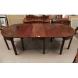 A Georgian mahogany extending dining table on square legs comprising a pair of demi-lune side /