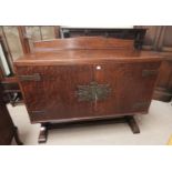 A 1930's oak sideboard with ornate brass hinges, 2 doors enclosing cellaret and drawers, on carved