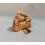 A Japanese carved Ivory Netsuke depicting a bearded man seated, height 3.5cm with label