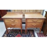 A similar pair of Arts and Crafts oak bedside cabinets, with two drawers.