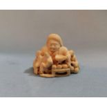 A late 19th / early 20th century Japanese carved ivory group Netsuke with red lacquer seal