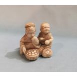 A Japanese carved Ivory Netsuke depicting a boy and a girl eating.