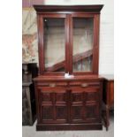 An Edwardian carved walnut full height bookcase with twin glazed doors over 2 drawers and double