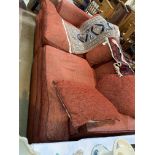 A large modern 3 seater settee in rust with leather effect piping