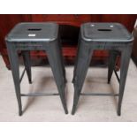 A pair of industrial style steel stools