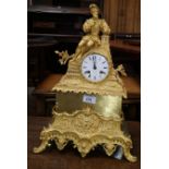 A 19th century French mantel clock in ormolu case, surmounted by reclining man in renaissance dress,