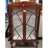 An Art Deco display cabinet with astral glazed doors on ball and claw feet