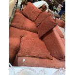 A large modern 3 seater settee in rust with leather effect piping