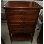 An Edwardian mahogany five drawer music cabinet on tapering legs with brass handles