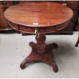 A Victorian style mahogany drum table, with circular top on carved column and scroll feet