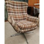 A 1970's egg shaped swivel armchair in brown check, on stainless steel base (sold as a collectors
