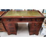 A reproduction mahogany desk with leather effect insert and nine drawers