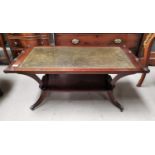 An early 20th century mahogany occasional table with leather insert and book rack below
