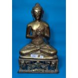 A large brass and copper coloured buddha sat in meditative pose, height 38cm