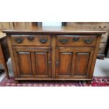 An 18th century style oak dresser base with 2 frieze drawers and 2 double fielded panel doors, the