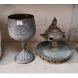 A Middle Eastern silvered goblet and a brass oil lamp