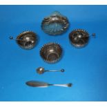 A set of 3 silver circular salts with folded rims and embossed decoration, matching spoons,