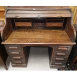 An early 20th century oak 'S' scroll top desk with fitted interior, kneehole base and 8 pedestal