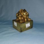 A large Chinese gilt cast metal seal with mythical beast to the top