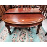 A late 19th/early 20th century mahogany dining table of rounded rectangular form, with wind out