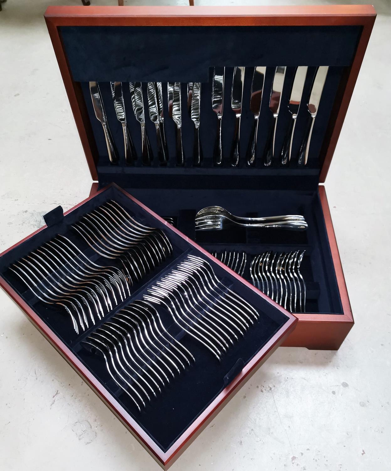 A 6 setting canteen of Alessi stainless steel cutlery in mahogany case