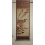 A Japanese scroll painting of a seated tiger with character and seal marks, length 125cm