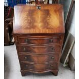 A mahogany reproduction bureau with serpentine front and 4 drawers