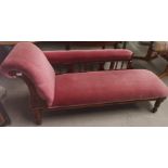 An Edwardian stained frame chaise longue on turned legs, pink dralon upholstery