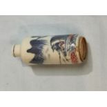 A Chinese porcelain cylindrical snuff bottle decorated in underglaze blue and red with a pastoral